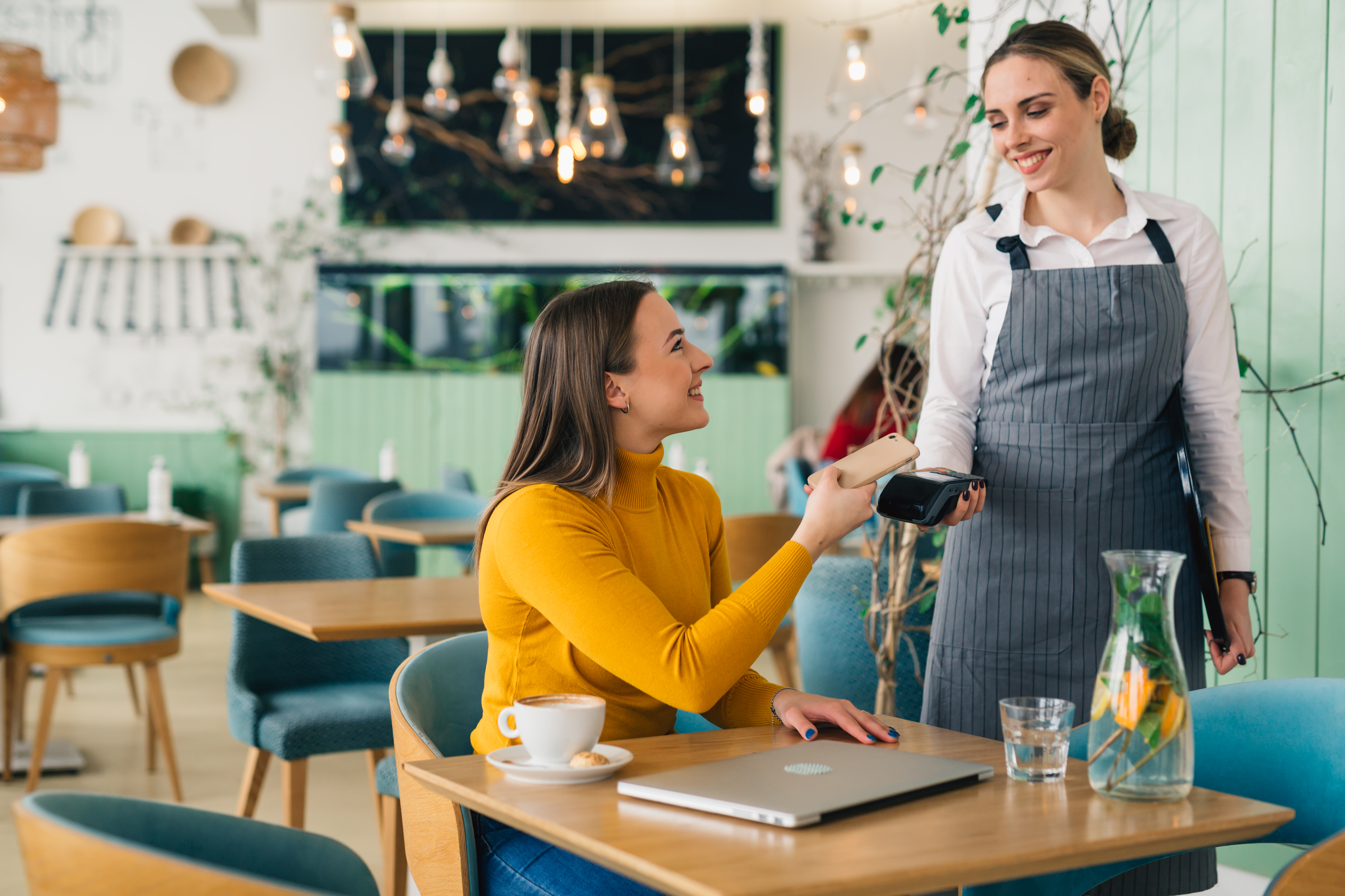 Woman paying for coffee with phone