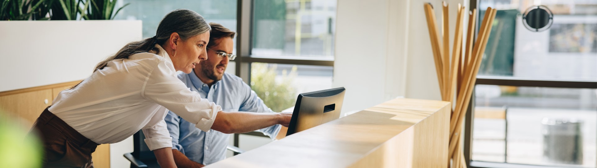 A man and woman in discussion looking at a laptop