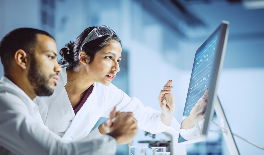 Two lab workers looking at a screen