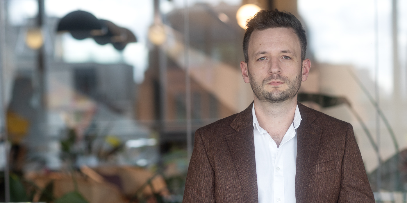 A professional headshot of Tom Harper