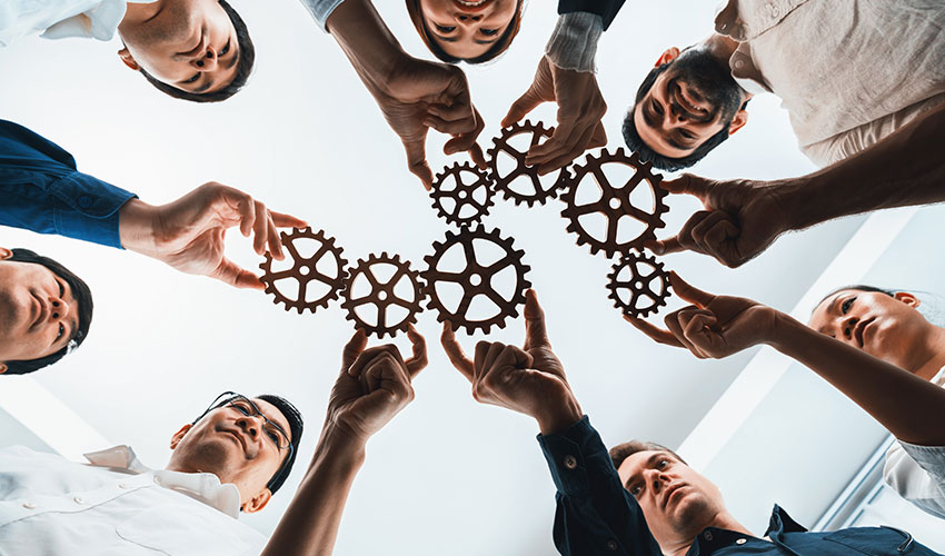 Group of people holding cogs together