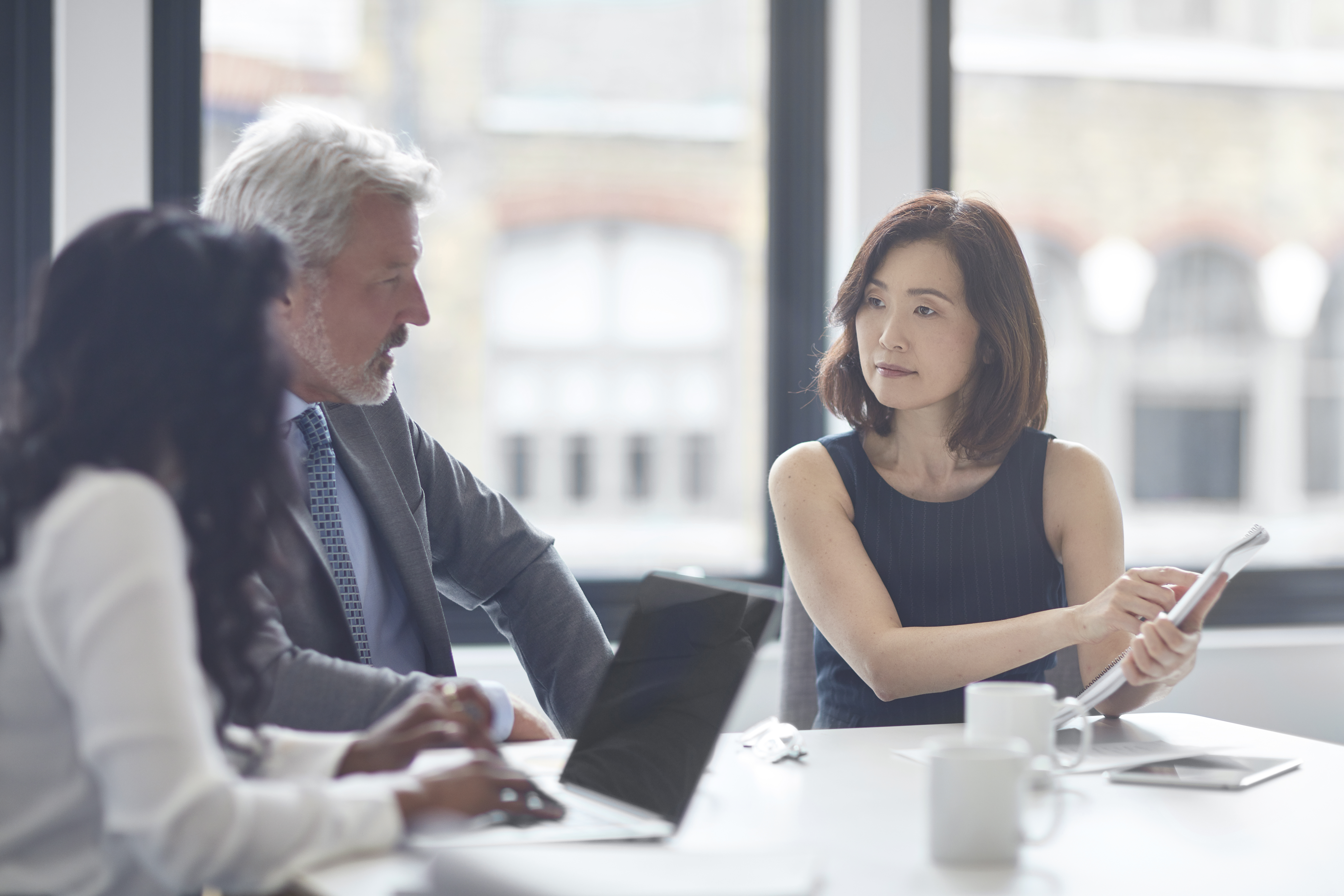 Businesswoman showing her notes to colleagues in a meeting