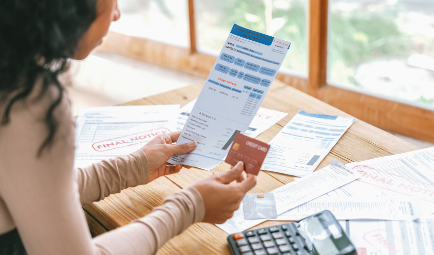Person looking at a bill and holding a credit card