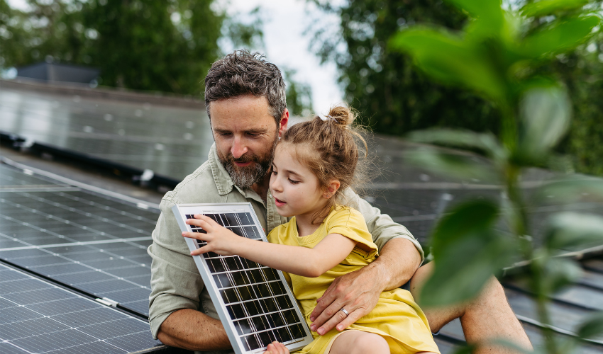Father and daughter on the rooftop full of solar panels