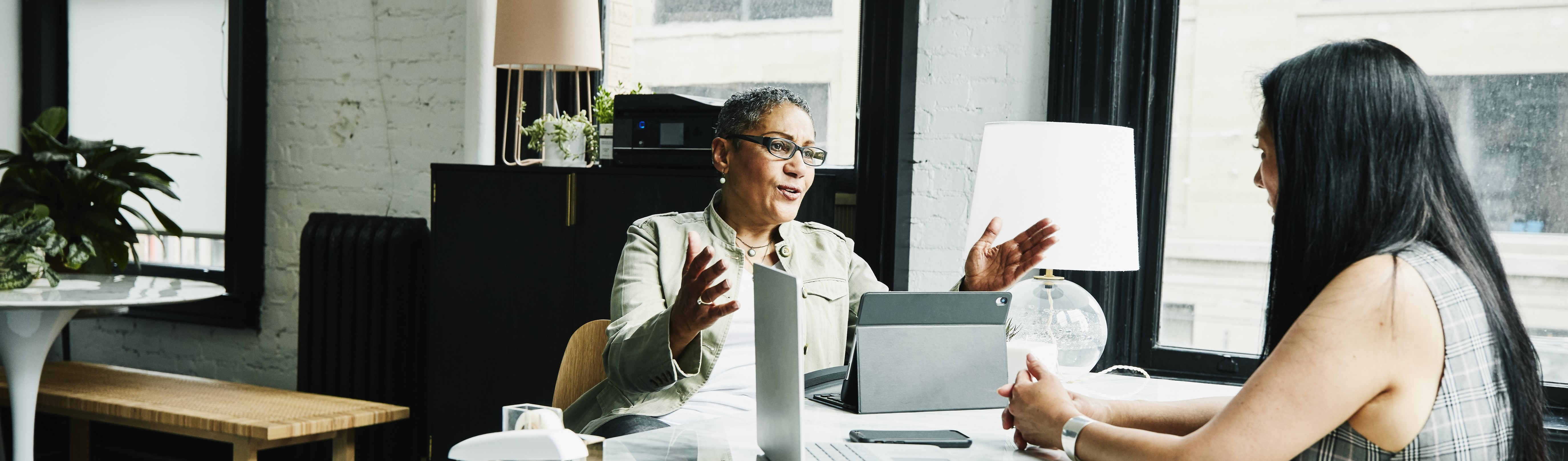 Two businesswomen having a discussion at a desk