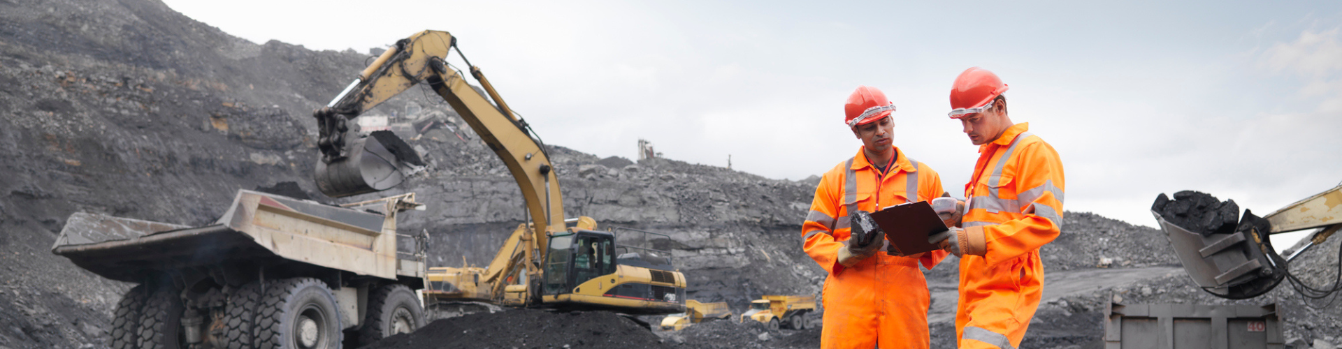 Two mine workers looking at a clipboard