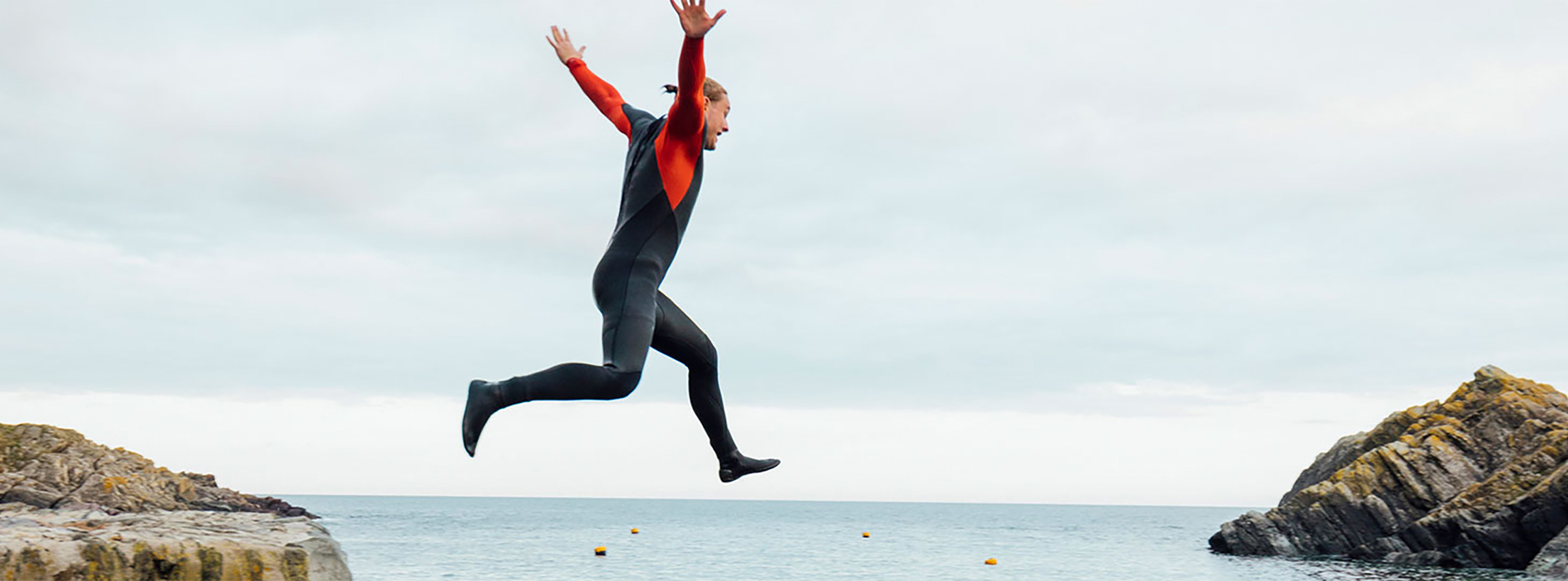 A person jumping from a harbour wall into the sea