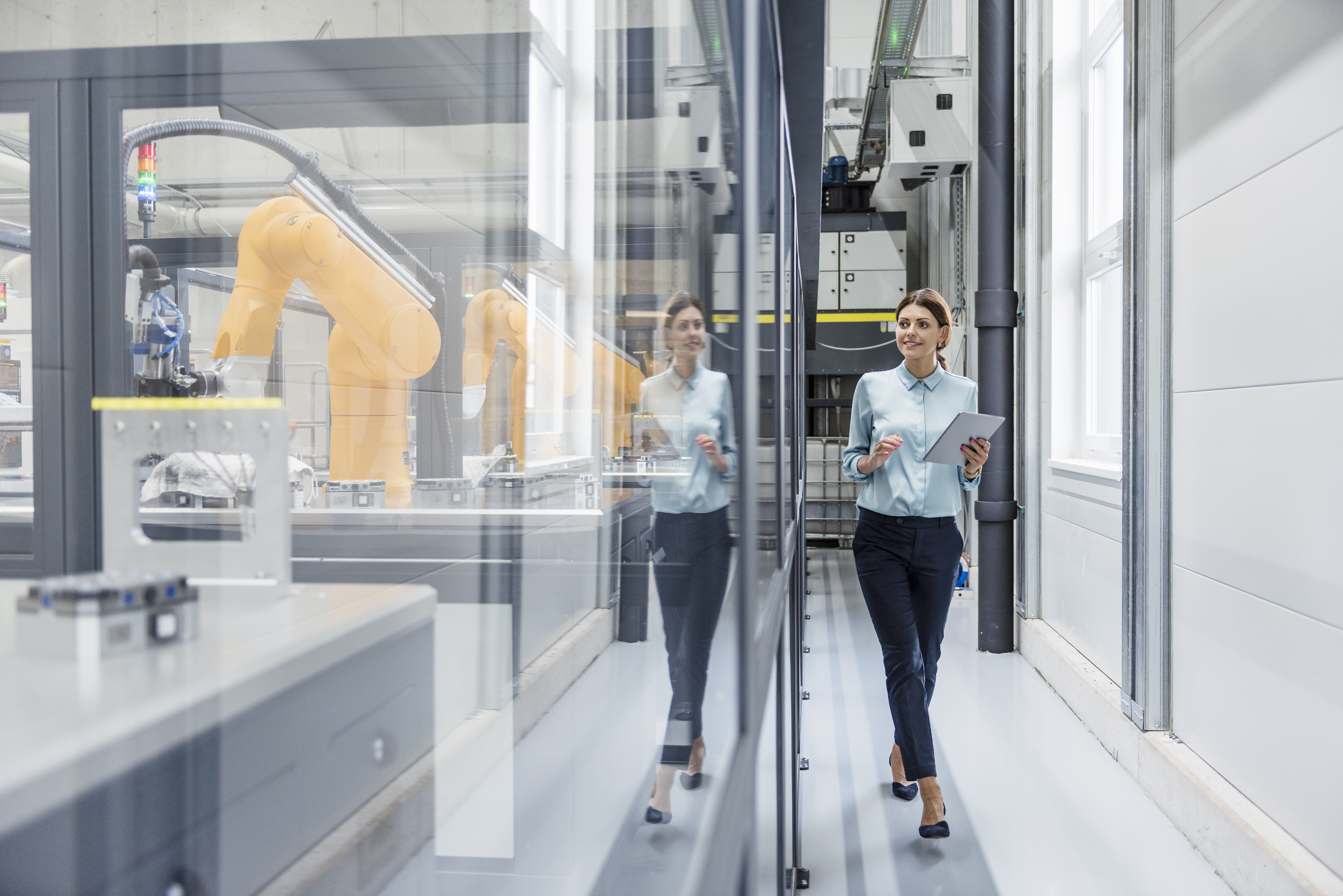 A woman with a clipboard in a manufacturing plant