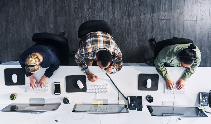 Three people seen from above working on their desks