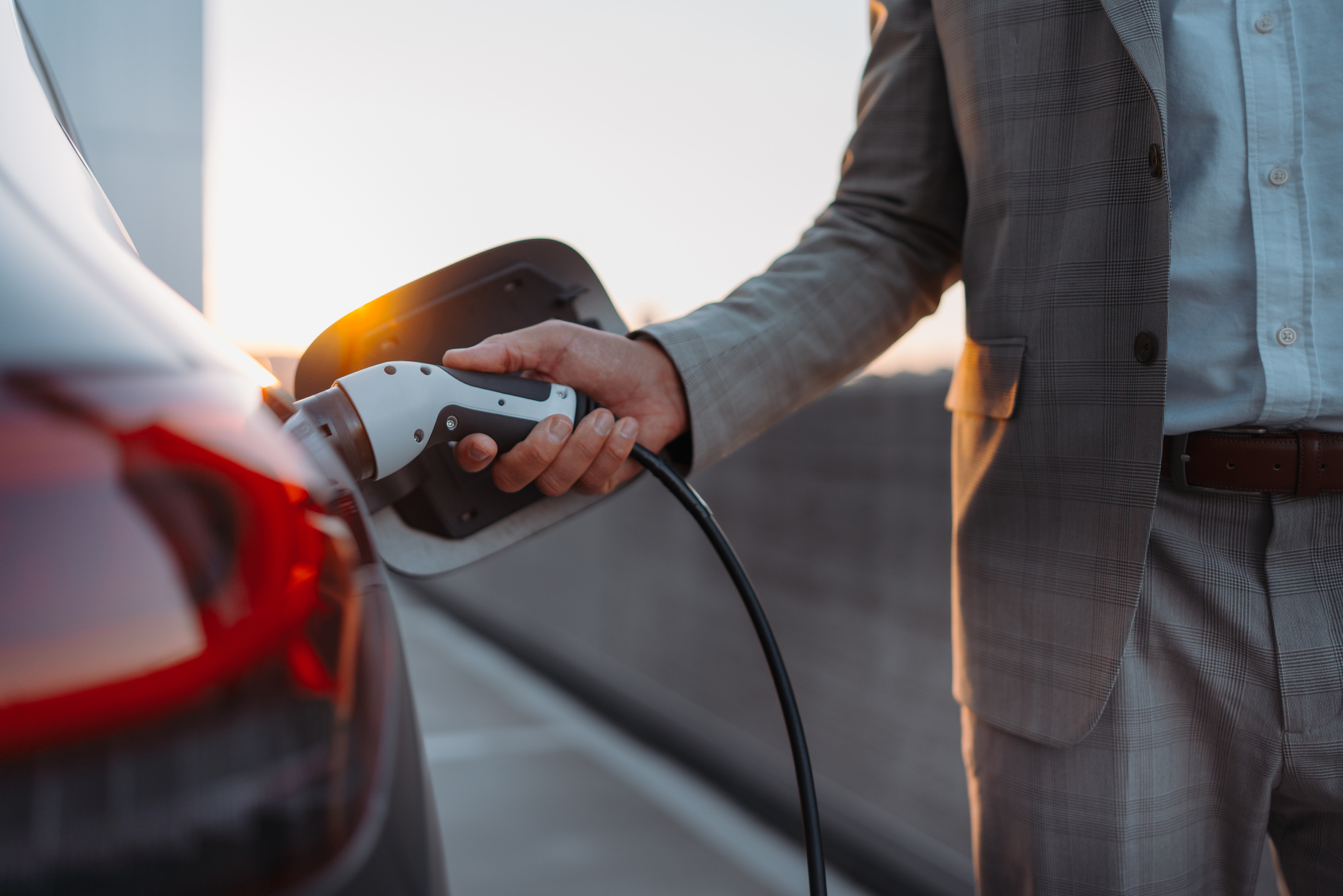 A man charging an electric vehicle