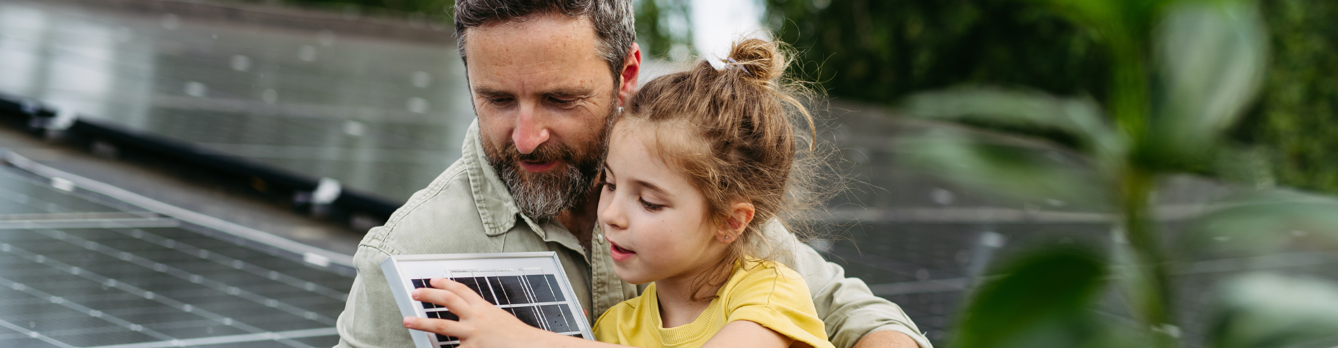 Father and daughter on the rooftop full of solar panels