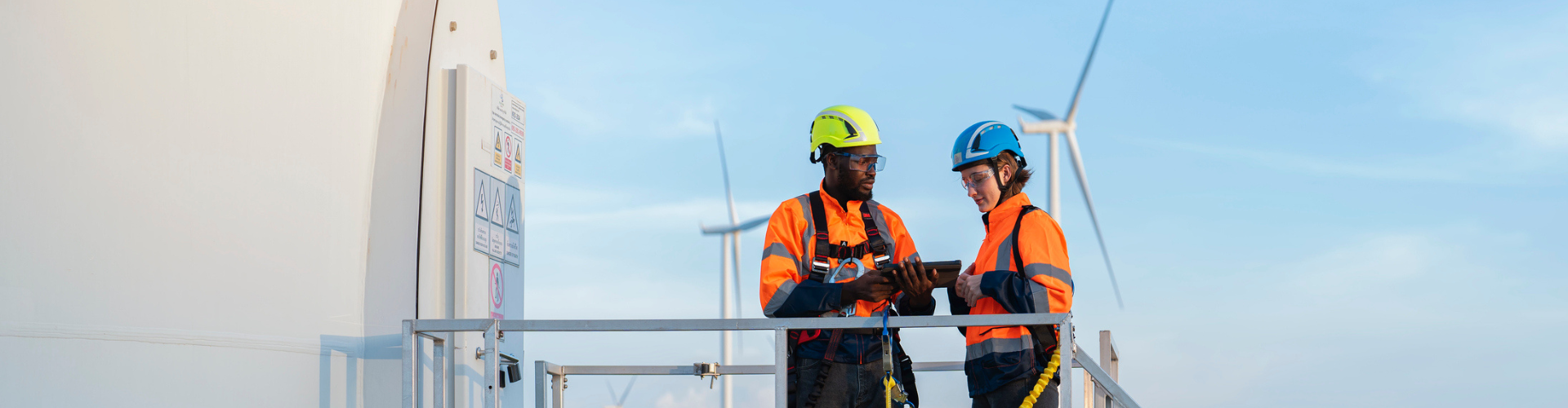 Two workers inspecting a wind turbine