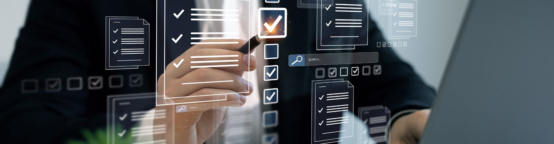 Man holding a pen in front of a laptop