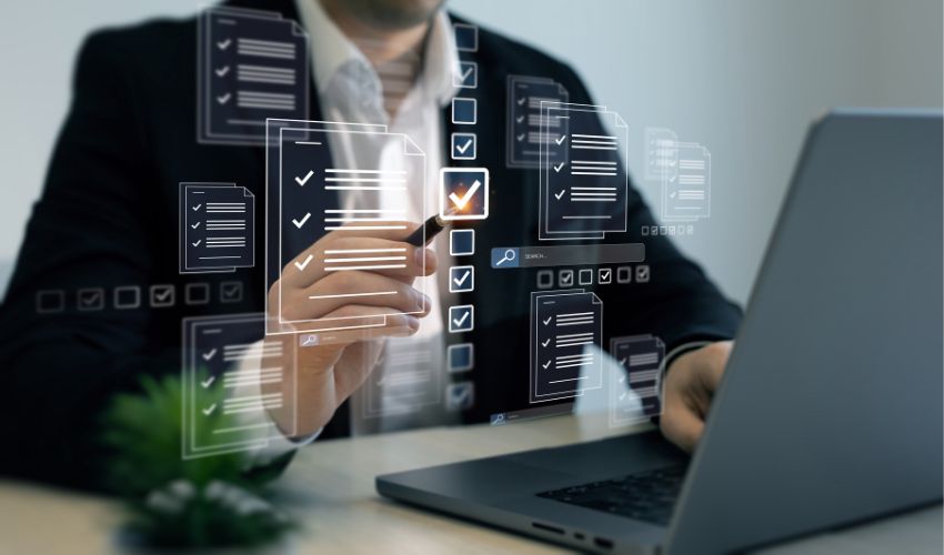 Man holding a pen in front of a laptop