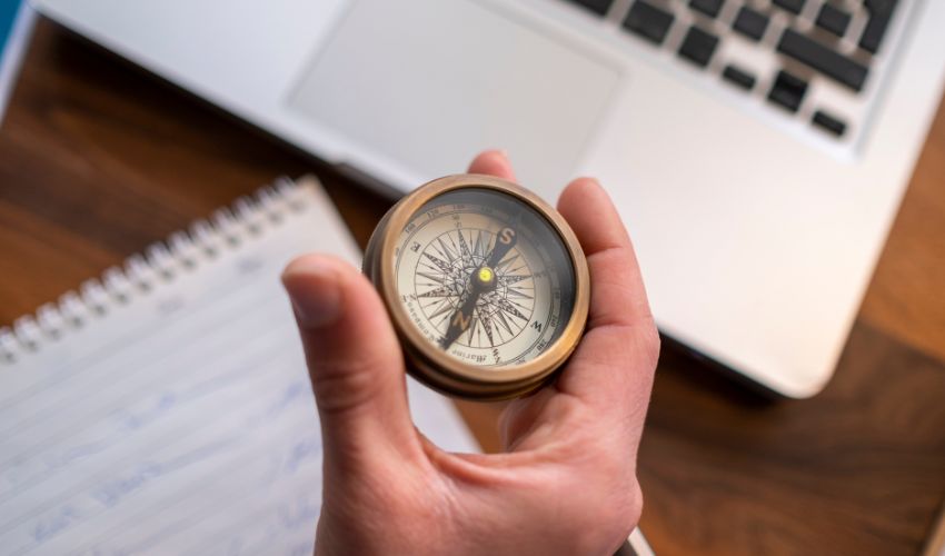 Hand holding a compass