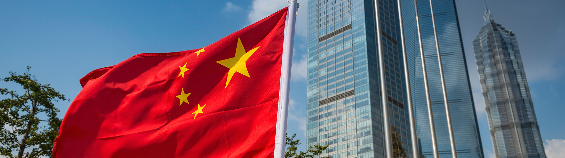 China Flag flying in front of skyscrapers
