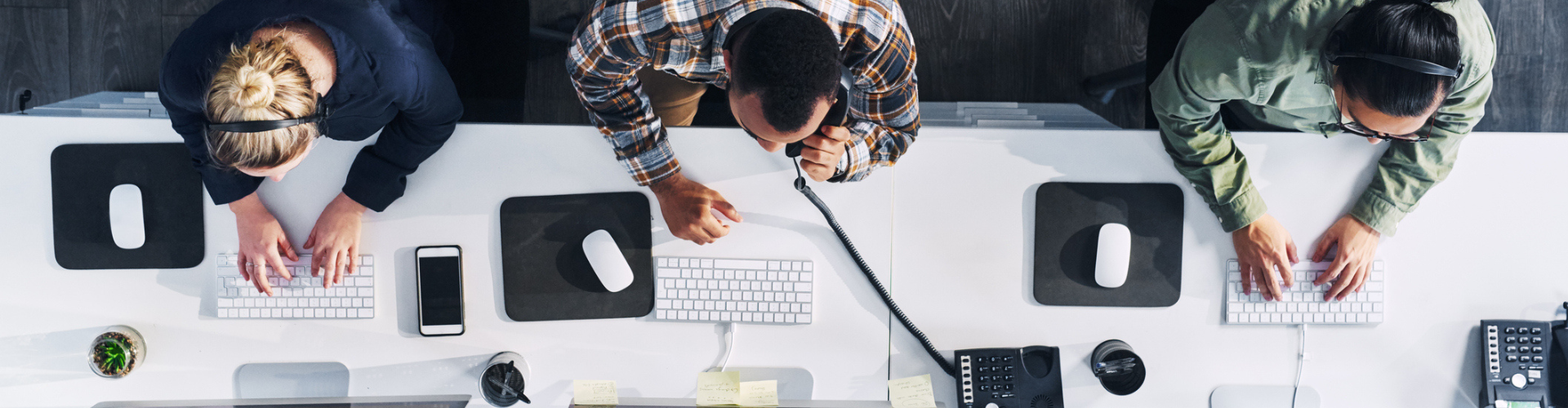 Three people seen from above working on their desks