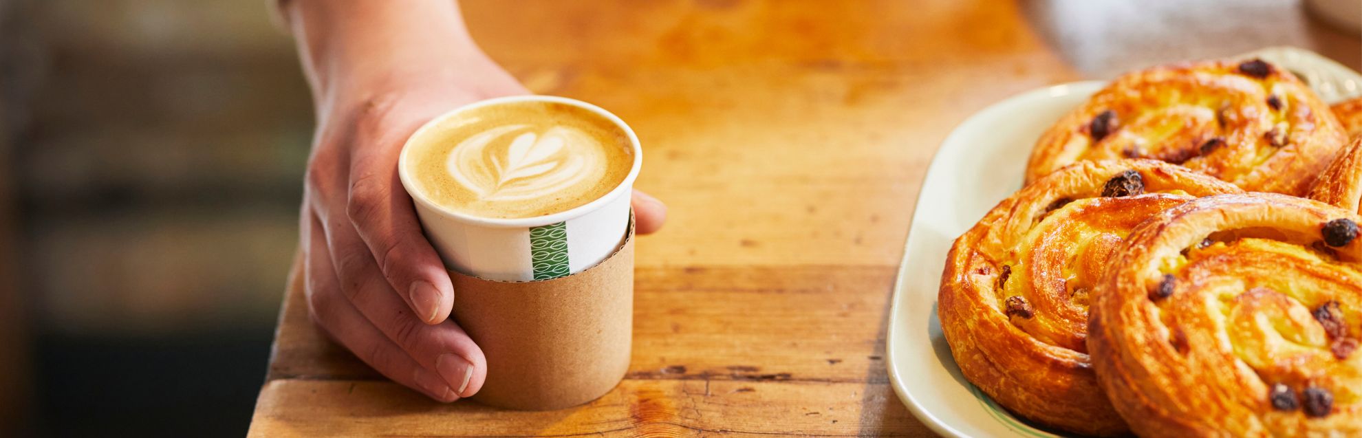 Close up of man's hand serving a coffee at a coffee shop
