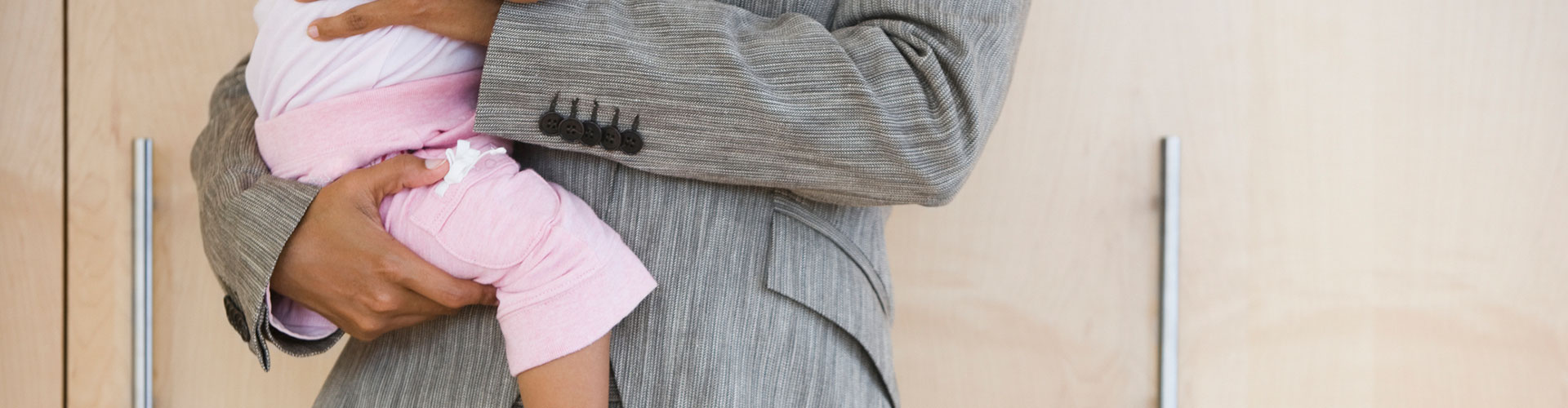 African American businesswoman holding baby
