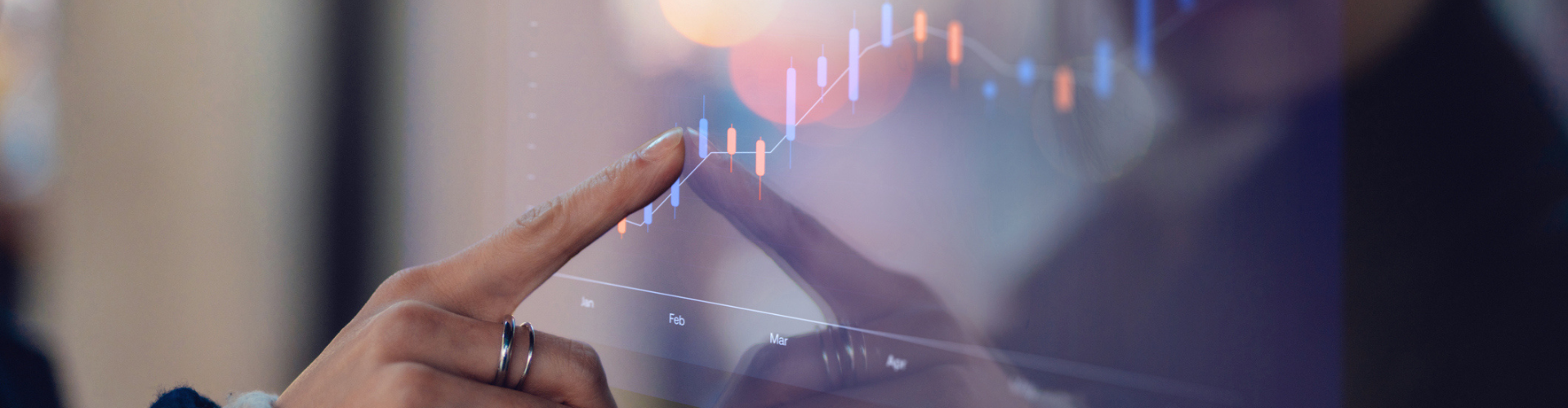 Finger touching a screen that is displaying a graph