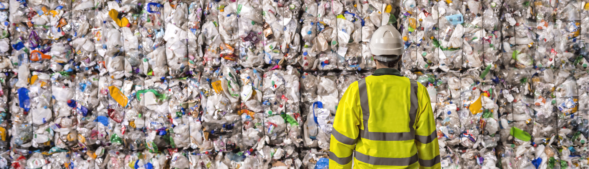 Worker looking at piles of plastic