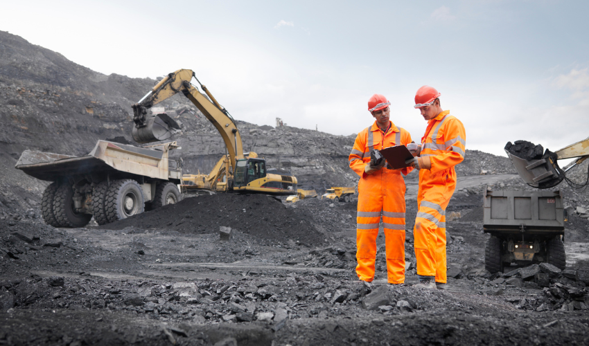 Two mine workers looking at a clipboard