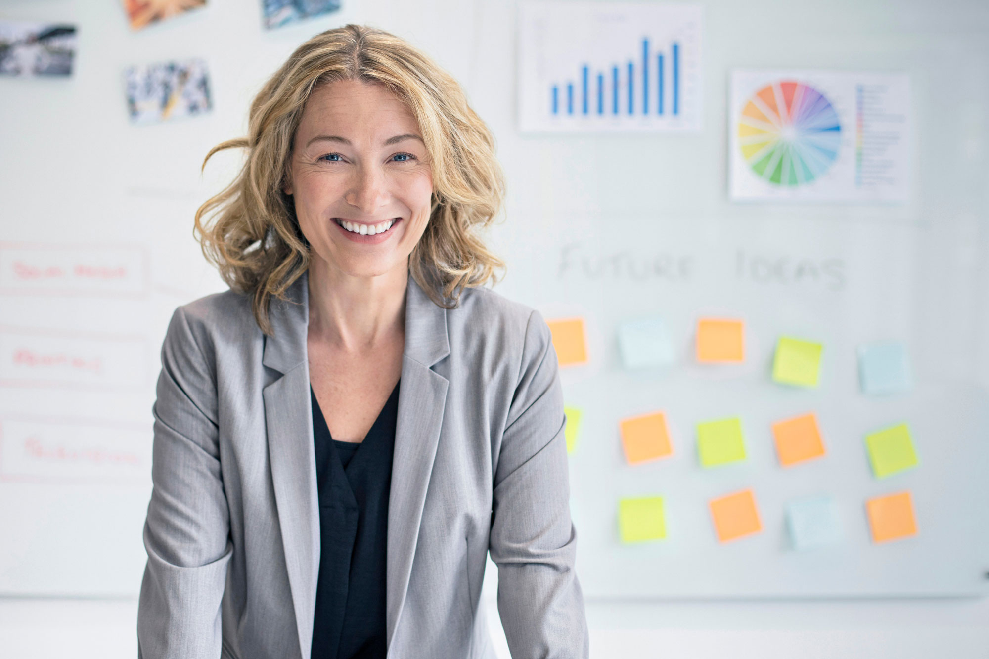 Woman smiling in front of whiteboard