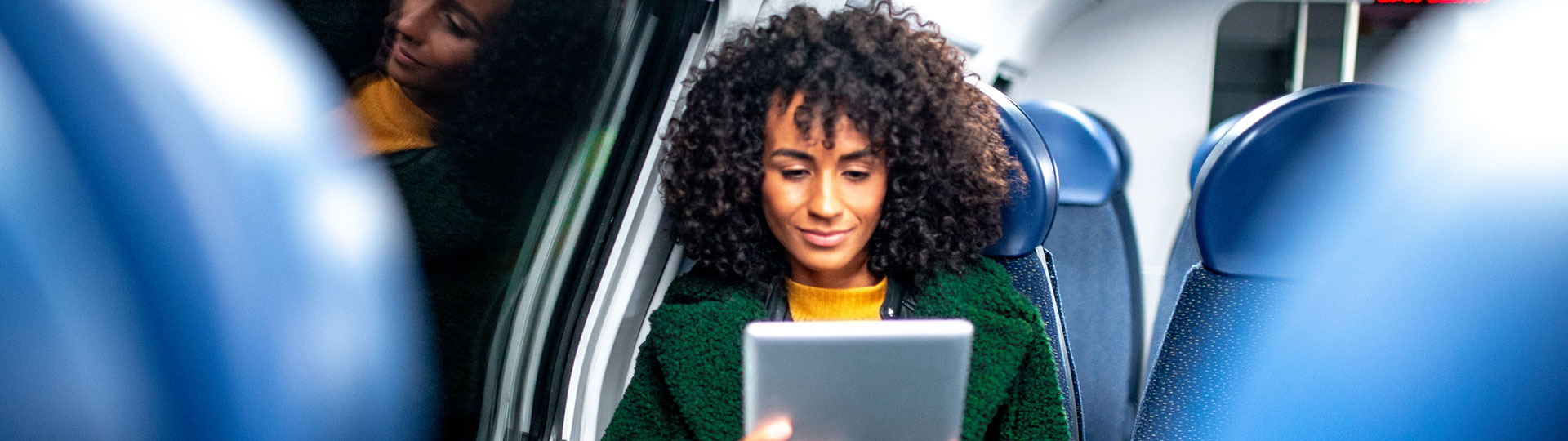 A woman sitting on a train looking at her phone