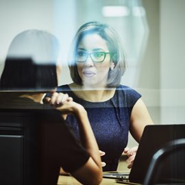 Two women in conversation with a laptop