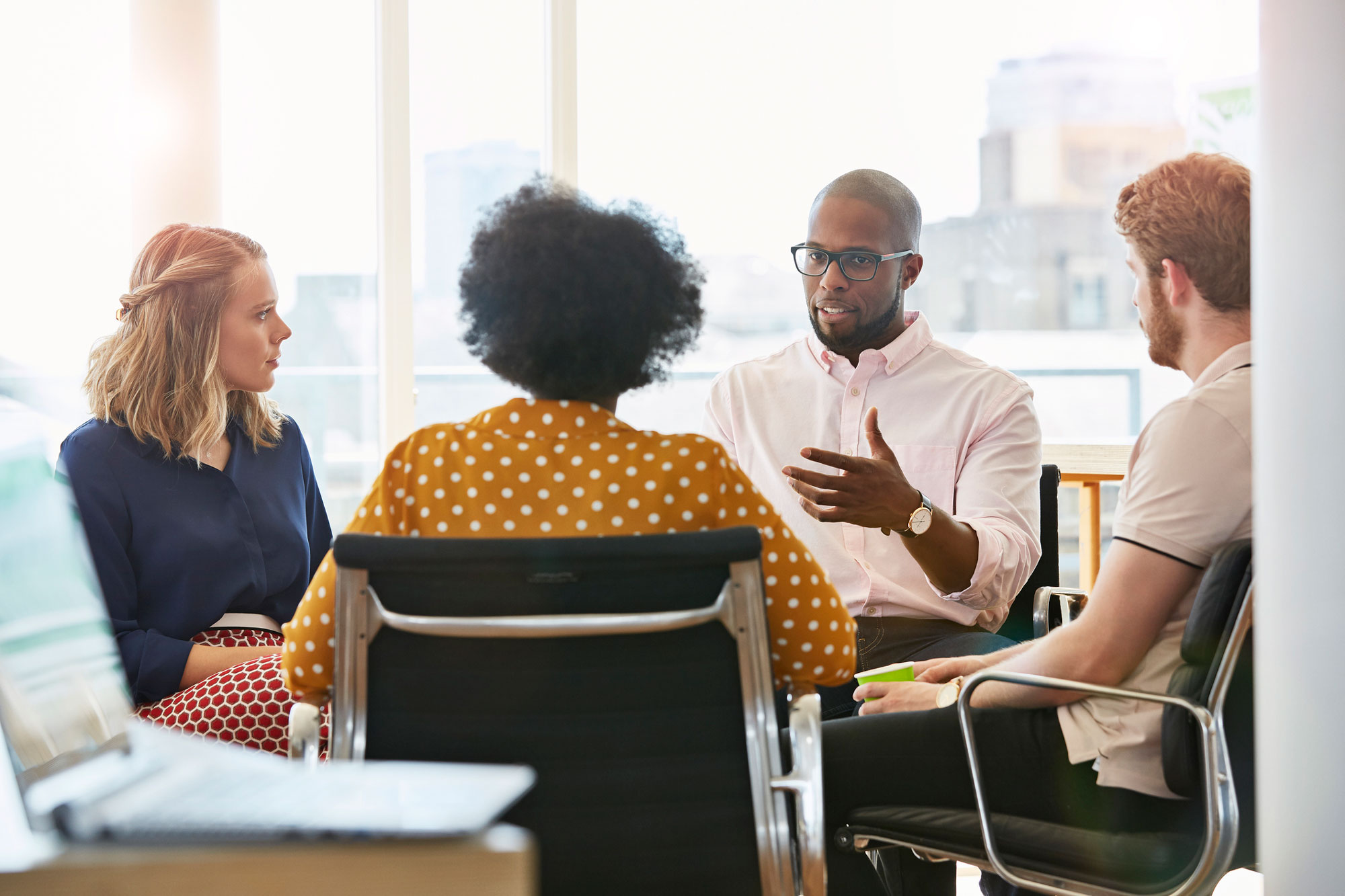 Four people having a discussion in an office