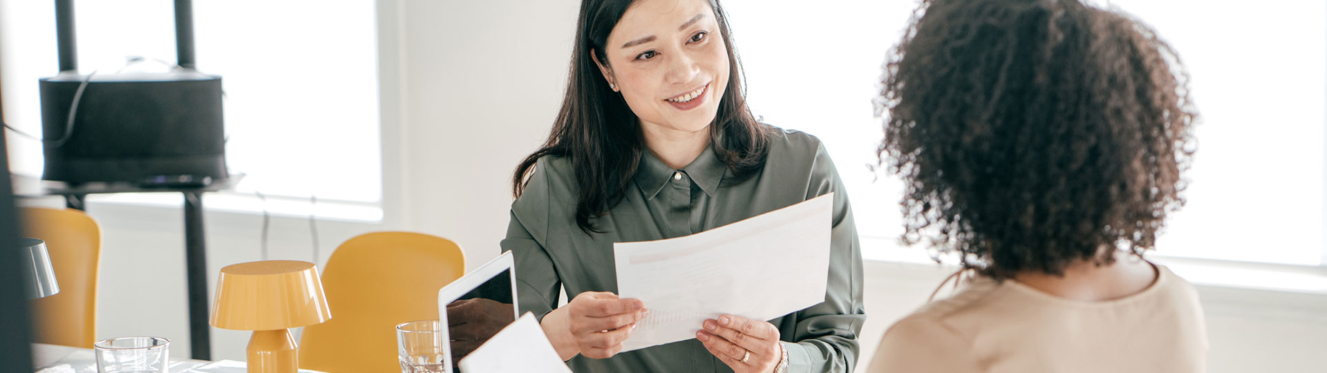 A women smiling and holding a report