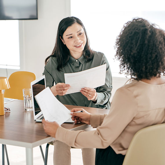 A women smiling and holding a report