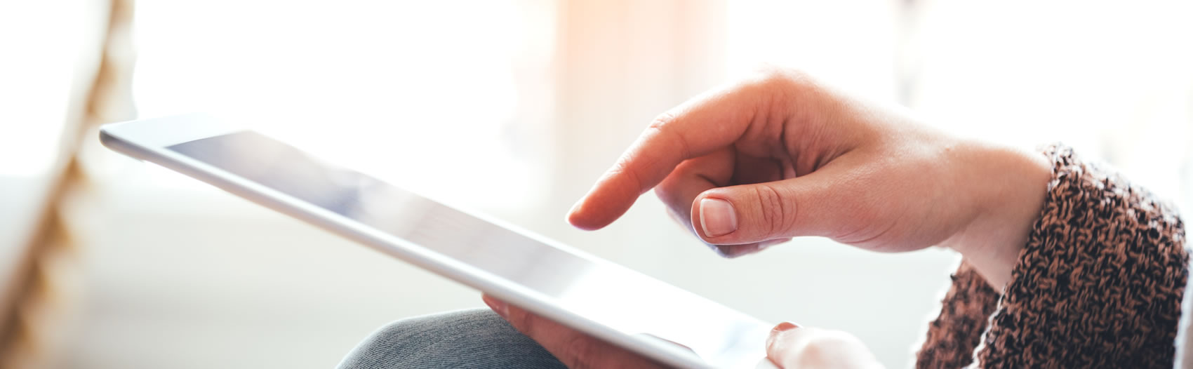 A hand with finger pointing to a tablet