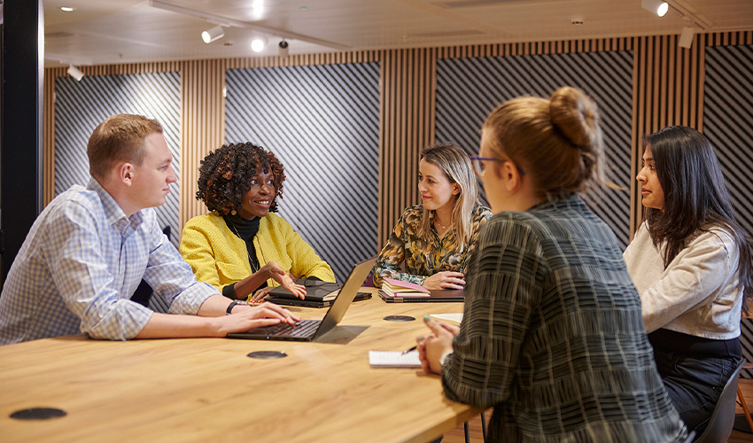 Five people having a meeting in a relaxed office environment