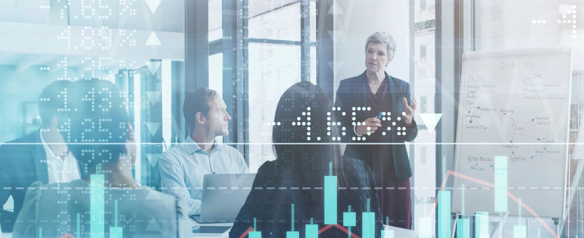 Businesspeople meeting in the boardroom superimposed over a graph showing the ups and downs of the stock market