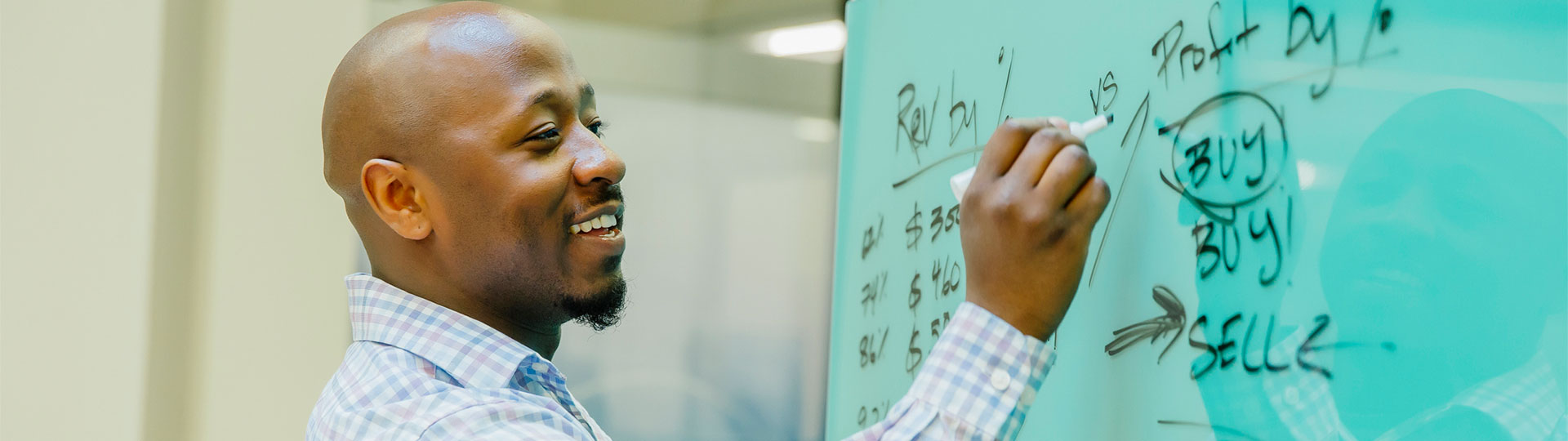 A man writing on a white board