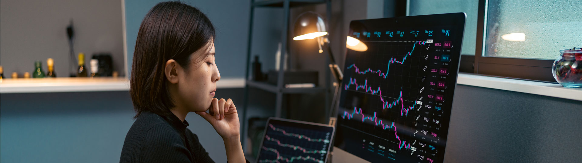  A woman looking at graphs on multiple screens