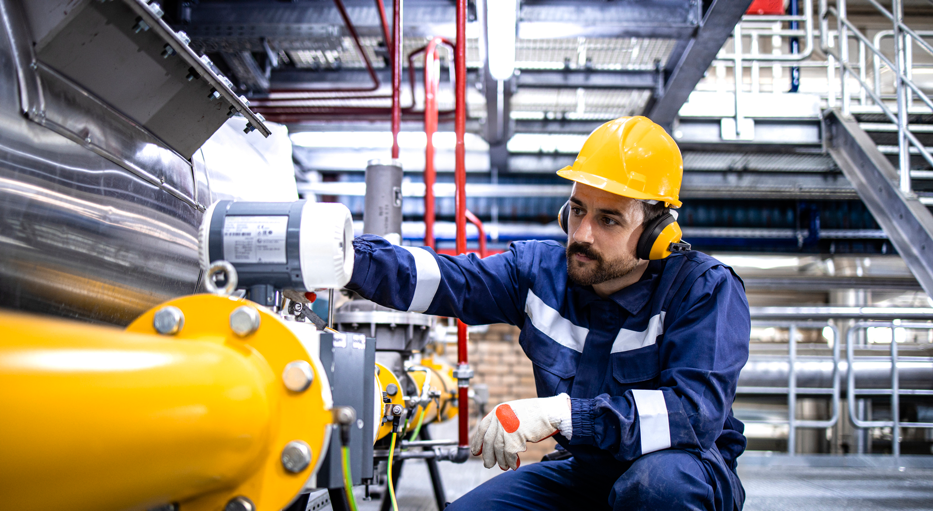 Refinery blue collar worker standing by LPG pipeline