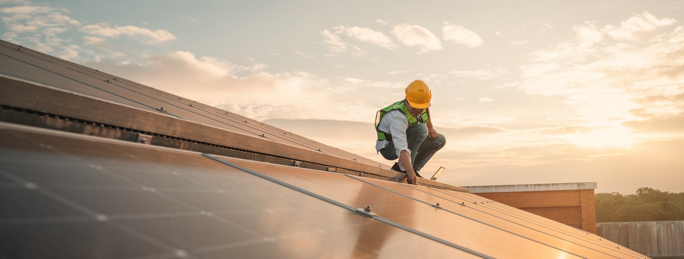 Male maintenance engineer walking with toolbox in the wind turbine field.
