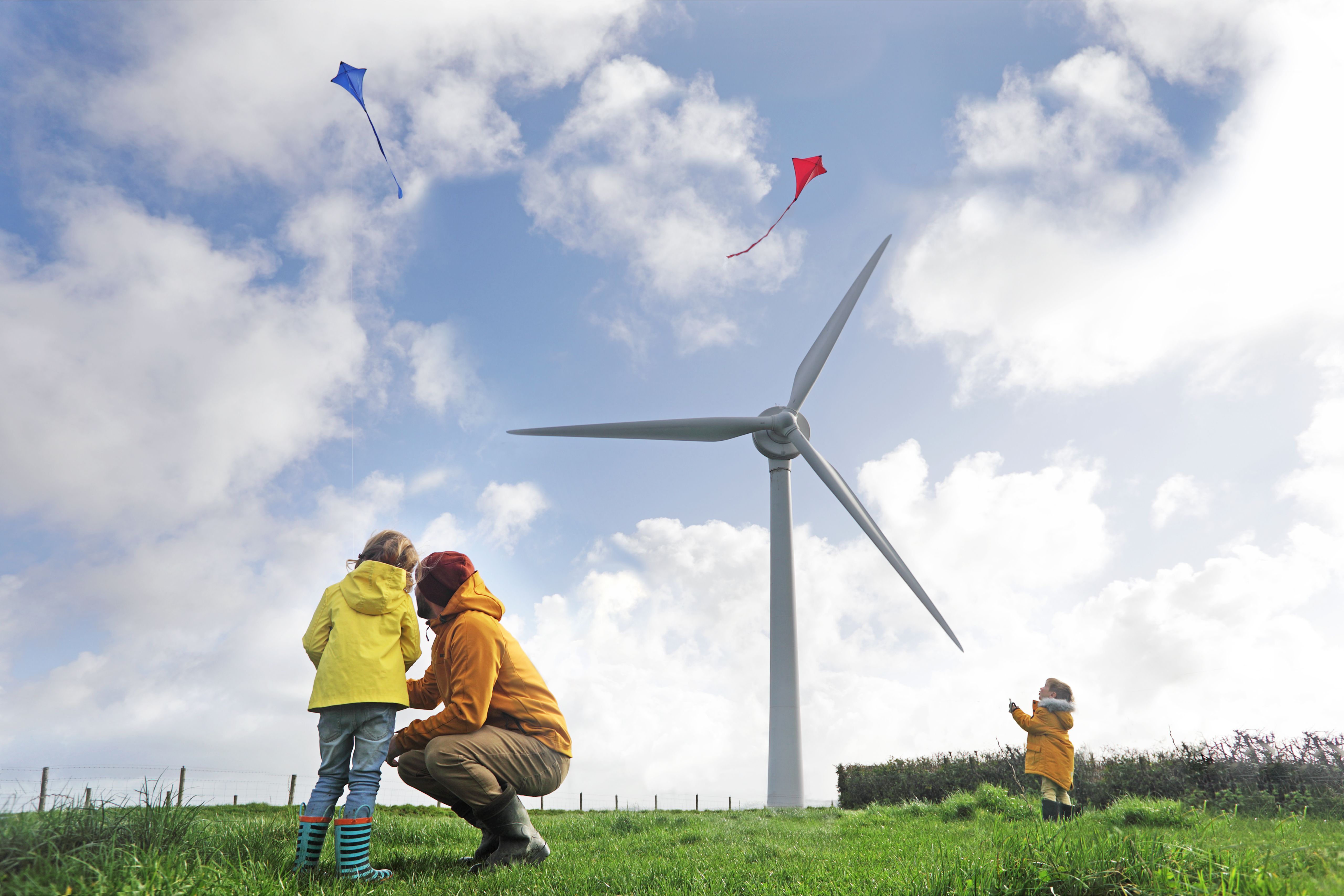 Father with his children in front of a wind turbine