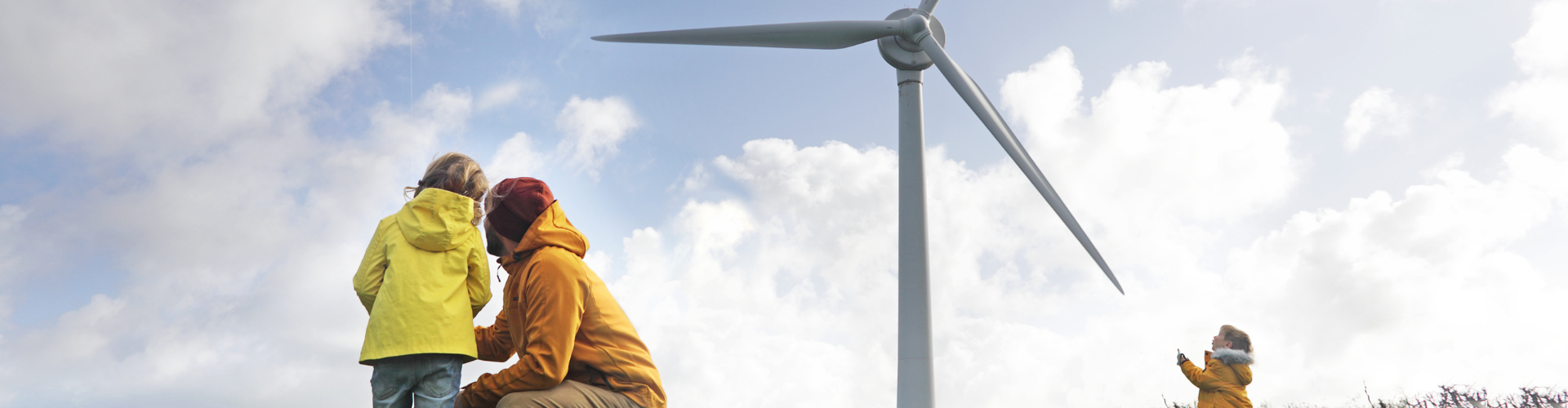 Father with his children in front of a wind turbine