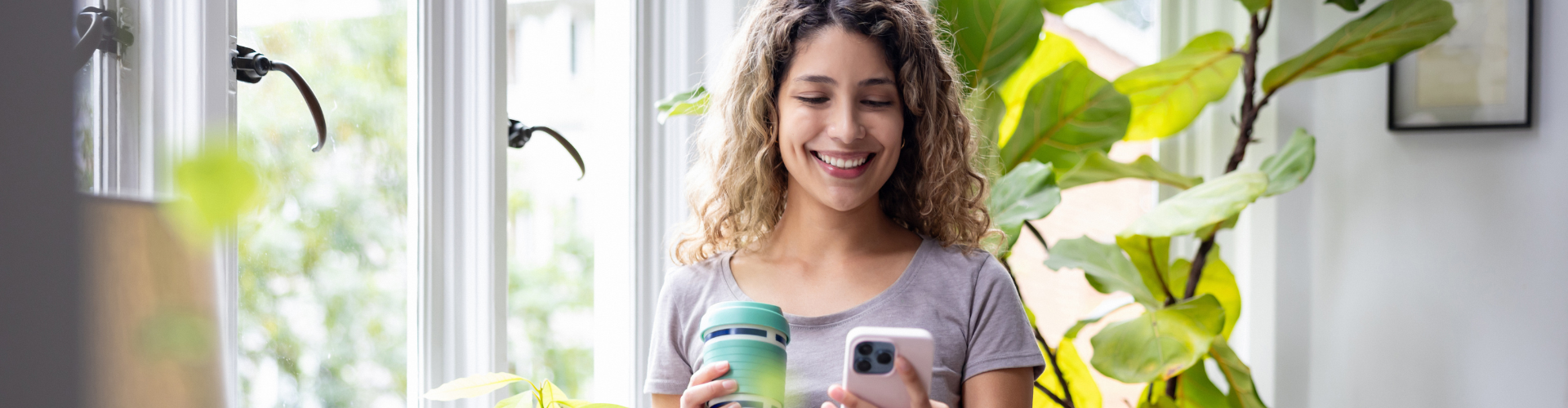 Happy woman looking at her home in a room with green plants