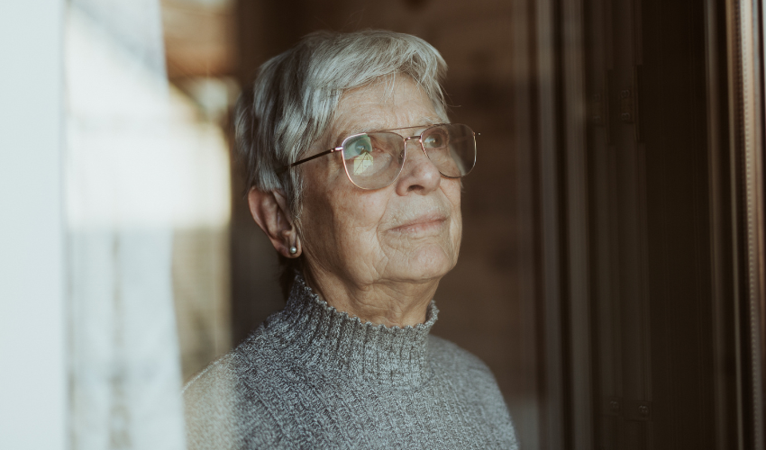 Elderly woman looking out of a window