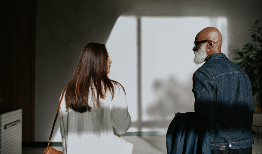 man and a woman standing next to each other, and walking away from the camera