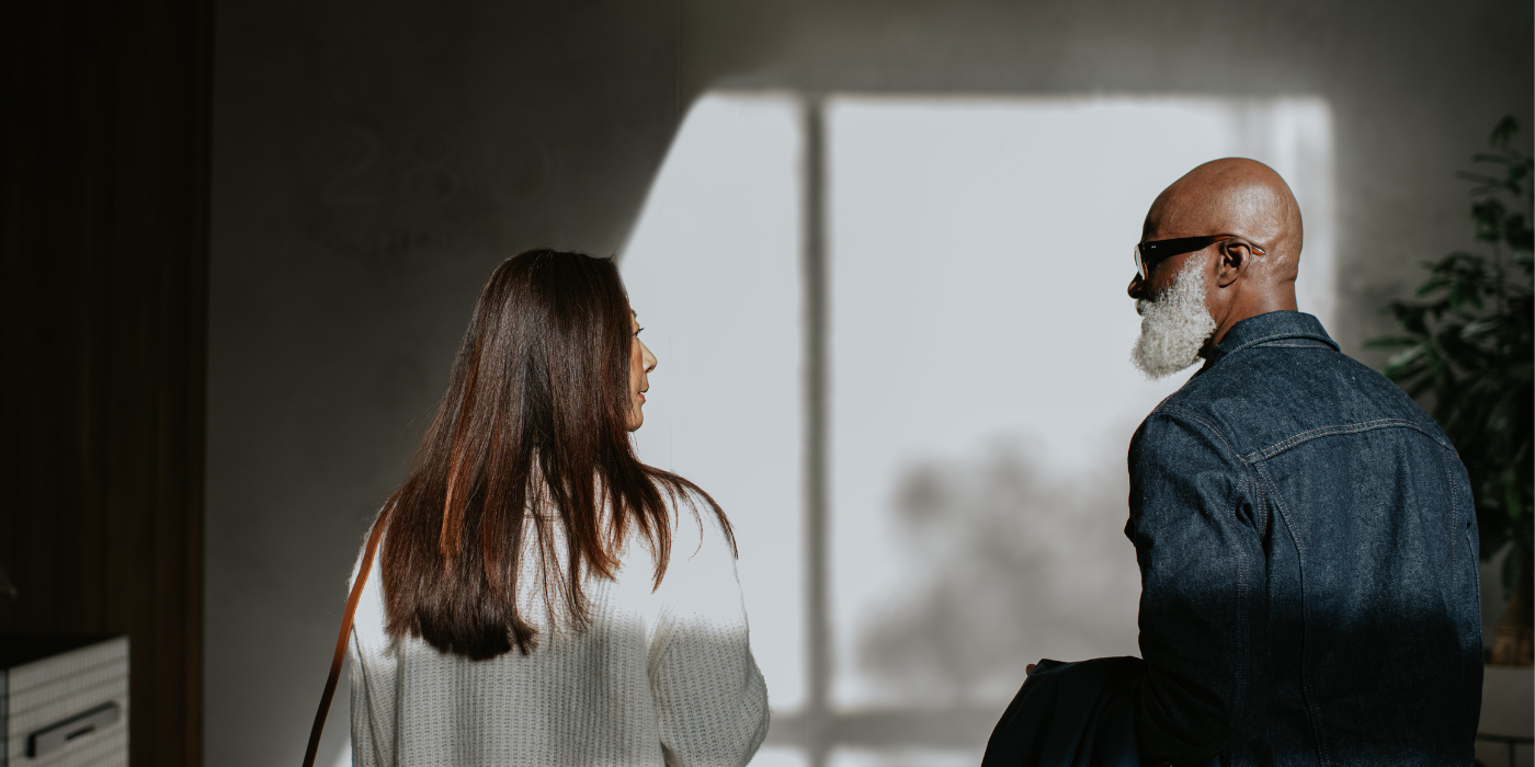 man and a woman standing next to each other, and walking away from the camera