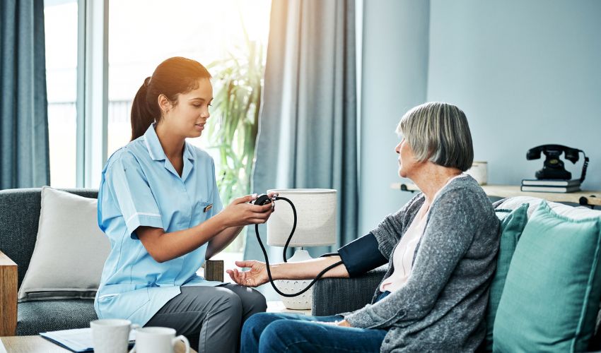 Nurse checking an elderly woman's blood pressure