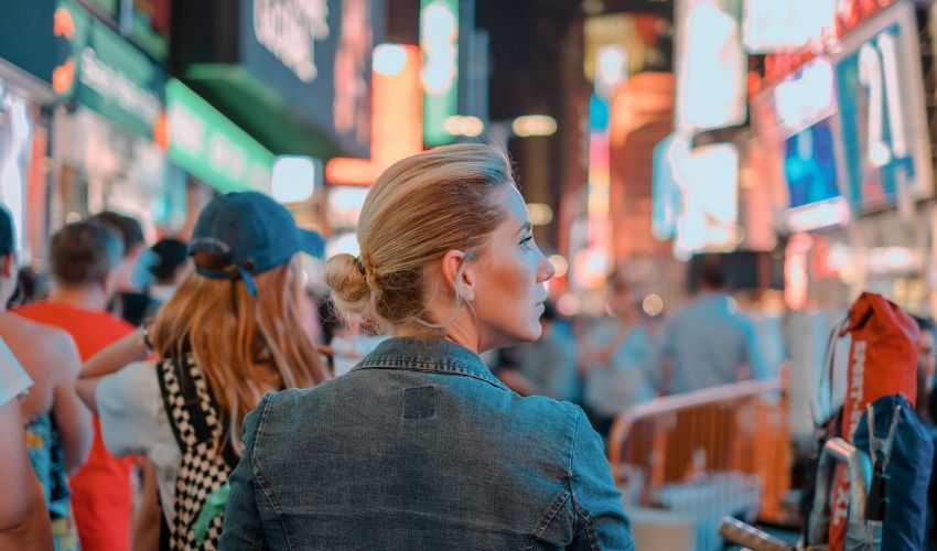 Woman stood in the city surrounded by advertising screens