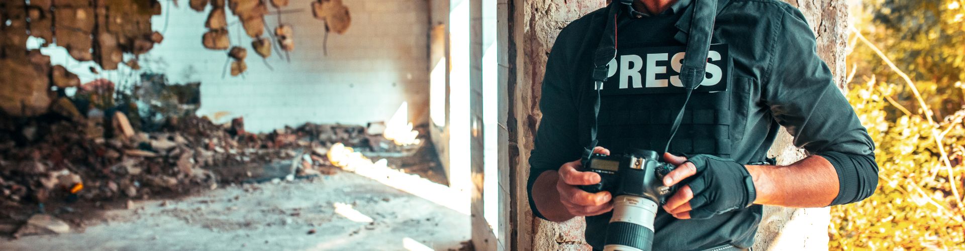 Man in press uniform taking photos in conflict