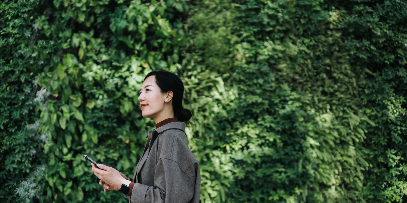 Business woman on phone in front of trees