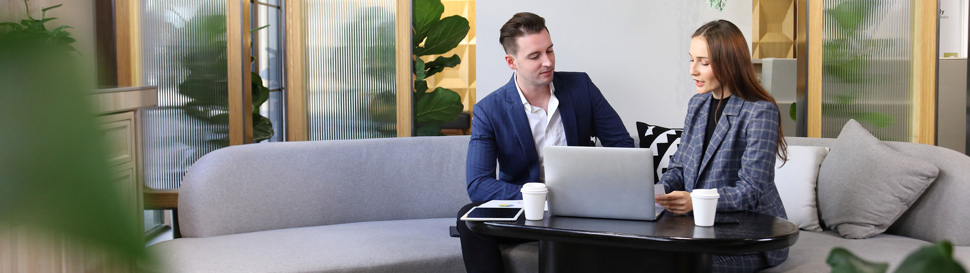 Two people looking at a laptop in a relaxed office environment